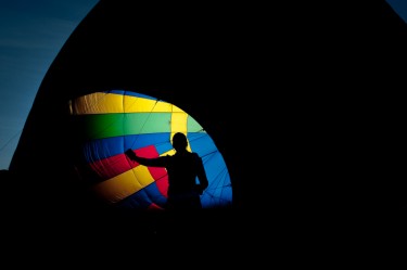 A pilot readies her hot air balloon at dawn. Littleton,  Colorado.