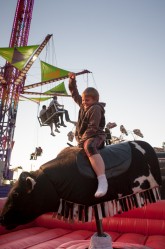 Logan Pierce, 7,  of Sanford rides a mechanical bull at the Rochester Fair in Rochester on Saturday.